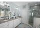 Bright bathroom with double sink vanity, large mirror, and separate glass shower at 2724 Sarzana Ln, Apopka, FL 32712