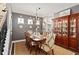 Formal dining room with a large wooden table, elegant chairs, a decorative chandelier, and hardwood floors at 2724 Sarzana Ln, Apopka, FL 32712