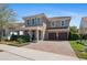 Attractive two-story house with a paver driveway leading to a two-car garage and a landscaped front yard at 2724 Sarzana Ln, Apopka, FL 32712