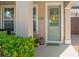 Inviting front entrance featuring a decorative wreath, lantern, potted plants, and the house number display at 2724 Sarzana Ln, Apopka, FL 32712