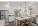 Bright and modern kitchen with white cabinets, stainless steel appliances, a center island, and stylish pendant lighting at 2724 Sarzana Ln, Apopka, FL 32712