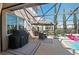 Screened patio featuring an outdoor kitchen and dining area near the pool at 2724 Sarzana Ln, Apopka, FL 32712