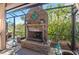 Screened-in patio featuring a cozy stone fireplace and lovely outdoor decor at 2724 Sarzana Ln, Apopka, FL 32712