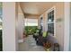 Cozy covered porch with comfortable seating, decorative plants, and a view of the manicured front yard at 2724 Sarzana Ln, Apopka, FL 32712