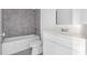 A bathroom with white fixtures and gray tile at 2788 Pierr St, Davenport, FL 33837