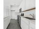 Modern kitchen features white cabinets, stainless steel appliances, and gray tile flooring at 2788 Pierr St, Davenport, FL 33837