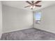 Bright bedroom features soft gray carpet, a ceiling fan, and a window for natural light at 3010 Ballad Rd, Kissimmee, FL 34746