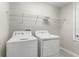 Laundry room featuring a washer and dryer with wire shelving for storage space at 3010 Ballad Rd, Kissimmee, FL 34746