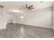 Open living room showcasing a ceiling fan, modern chandelier and gray wood-look tile flooring at 3010 Ballad Rd, Kissimmee, FL 34746