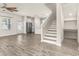 Open floor plan featuring a living room, kitchen, and staircase with light-colored walls at 3010 Ballad Rd, Kissimmee, FL 34746