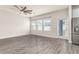 Spacious living room with three large windows, fan, and sliding glass door for natural light at 3010 Ballad Rd, Kissimmee, FL 34746