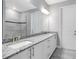 Bathroom featuring dual sinks, granite countertops, and a tiled shower at 30340 W Bluebell Ave, Eustis, FL 32736