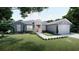 Charming single-story home with a manicured lawn, landscaped garden beds, and a two-car garage at 30340 W Bluebell Ave, Eustis, FL 32736