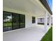 Covered outdoor patio featuring sliding glass doors, white columns and ceiling with views of the backyard at 30340 W Bluebell Ave, Eustis, FL 32736