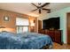 Comfortable bedroom with a ceiling fan, large window, and a dresser with a large television at 358 Douglas Way # 78, Winter Garden, FL 34787