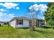 Exterior side view of this charming home with a well-maintained lawn, screened porch and red window shutters at 381 Corbett Dr, The Villages, FL 32162