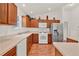 Bright kitchen featuring wood floors, cabinets, stainless steel fridge, and white appliances at 381 Corbett Dr, The Villages, FL 32162