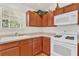 Cozy kitchen with ample cabinet space, white appliances, and a window over the sink at 381 Corbett Dr, The Villages, FL 32162