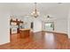 Open living space with wood floors leading to a kitchen and bright window at 381 Corbett Dr, The Villages, FL 32162