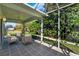 A screened patio with stone floors, overhead fan, and outdoor seating provides a relaxing outdoor living space at 381 Corbett Dr, The Villages, FL 32162