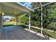 Spacious screened porch with stone tile flooring, a ceiling fan and backyard view for outdoor relaxation at 381 Corbett Dr, The Villages, FL 32162