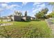 Wide view of the fenced backyard with a spacious grassy area and storage shed at 3905 Cherry Way, Lakeland, FL 33805