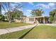 Single-story home with a covered carport, a well-maintained lawn, and mature trees at 3905 Cherry Way, Lakeland, FL 33805