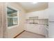 Bright kitchen featuring all-white cabinetry, backsplash, and appliances with a window view at 3905 Cherry Way, Lakeland, FL 33805