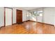 Bright living room featuring hardwood floors, a dark wood door, and large windows at 3905 Cherry Way, Lakeland, FL 33805