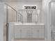 Modern bathroom featuring double sinks, white cabinets, and a glass-enclosed shower at 4198 Sw 128Th Pl, Ocala, FL 34473