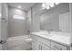 White bathroom featuring tile flooring, white vanity, and tiled shower-tub at 4198 Sw 128Th Pl, Ocala, FL 34473