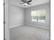 Bright bedroom with plush gray carpet, a large window, and a modern ceiling fan at 4198 Sw 128Th Pl, Ocala, FL 34473