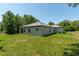 Back and side view of the house, showing the back patio, windows, and large grassy yard at 4198 Sw 128Th Pl, Ocala, FL 34473