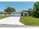 Well-manicured lawn complements this single-story home featuring a spacious driveway leading to a convenient two-car garage at 4198 Sw 128Th Pl, Ocala, FL 34473