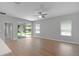 Spacious living room featuring wood-look flooring, neutral paint, and sliding glass doors to the backyard at 4198 Sw 128Th Pl, Ocala, FL 34473