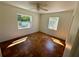 Bright bedroom featuring parquet floors, white walls, two windows, and a ceiling fan at 472 Rosalia Dr, Sanford, FL 32771