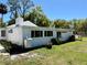 View of the rear exterior elevation featuring lots of windows and a well-maintained lawn at 472 Rosalia Dr, Sanford, FL 32771