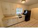 Compact kitchen featuring white cabinets, tile floors, and a practical layout for easy meal preparation at 472 Rosalia Dr, Sanford, FL 32771