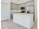 Bright kitchen features stainless steel appliances, quartz countertops, grey cabinetry and an island at 4914 Sw 147Th Loop, Ocala, FL 34473