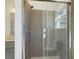 Walk in shower with a gray tiled surround and glass door at 4914 Sw 147Th Loop, Ocala, FL 34473