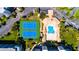 Overhead shot of a community pool, clubhouse, and tennis courts in a tropical setting, surrounded by green lawns at 5300 S Atlantic Ave # 7-301, New Smyrna Beach, FL 32169