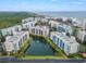 Stunning aerial view showcasing the community's beautiful architecture, landscaping, and central water feature at 5300 S Atlantic Ave # 7-301, New Smyrna Beach, FL 32169