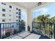 Balcony with blue railing and view of palm trees, and residential building at 5300 S Atlantic Ave # 7-301, New Smyrna Beach, FL 32169