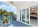 Relaxing balcony with blue railings overlooking lush tropical landscaping, accessible from bedroom at 5300 S Atlantic Ave # 7-301, New Smyrna Beach, FL 32169