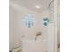 Bathroom featuring a large soaking tub next to a glass-block window and separate shower at 5300 S Atlantic Ave # 7-301, New Smyrna Beach, FL 32169