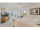 Bright bedroom with a ceiling fan, balcony access, a tropical view, and neutral carpet at 5300 S Atlantic Ave # 7-301, New Smyrna Beach, FL 32169