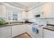 Bright kitchen featuring white cabinets, a double sink, and matching white appliances for a clean aesthetic at 5300 S Atlantic Ave # 7-301, New Smyrna Beach, FL 32169