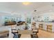 Bright open-concept living and dining area with a chandelier, comfortable sofas, and a bar with stool seating at 5300 S Atlantic Ave # 7-301, New Smyrna Beach, FL 32169