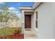Inviting front entrance with a solid wood door, sidelight window, and neatly landscaped garden at 600 Bullrush Ct, Davenport, FL 33837