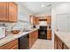 Well-equipped kitchen features wooden cabinetry, black appliances, and plenty of counter space at 600 Bullrush Ct, Davenport, FL 33837